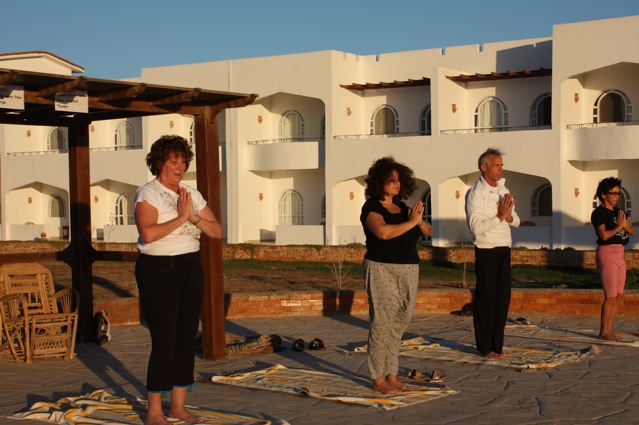 Yoga class at sunrise by the pool